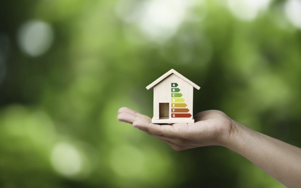 House energy efficiency, energy efficient rating class concept, eco home renovation save cost. Low-consumption ecological house. Hand holding Green Building for Sustainable Development Concept Riqualificazione energetica